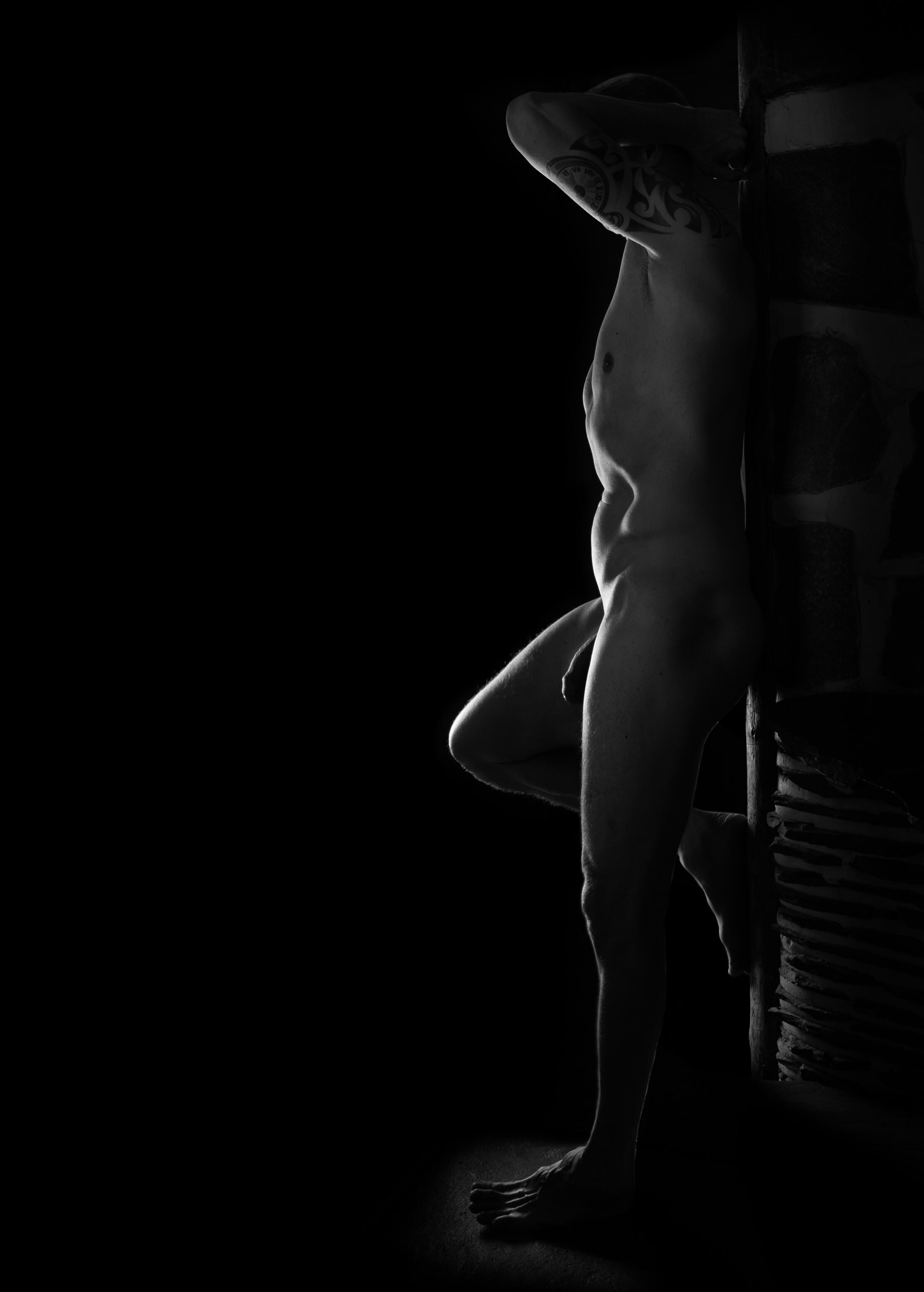 Nude tattooed man standing